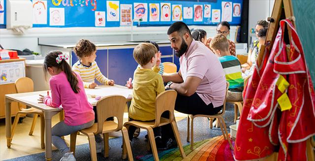 male teacher speaking with a young student