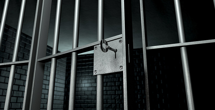 close up of a key in a jail cell door