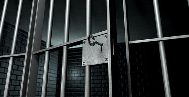 close up of a key in a jail cell door