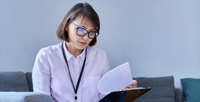 professional looking at notes on a clipboard