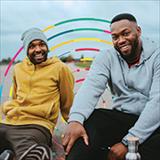 two men smiling and sitting near each other 