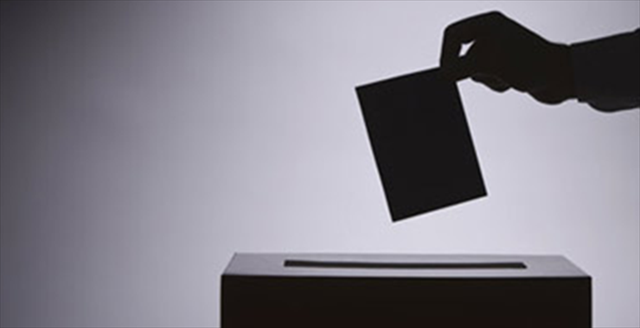 hand putting ballot in a box