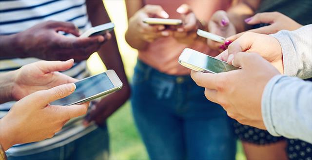 group of adults all using smartphones