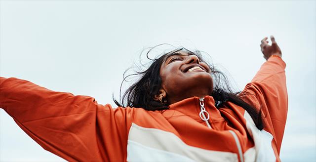 woman with hands in the air looking very happy