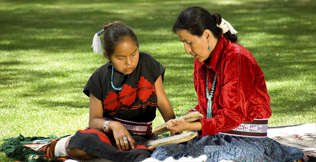 older Navajo woman talking with young Navajo girl