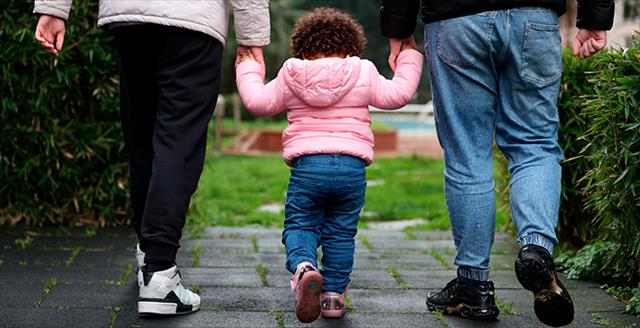 couple walking outside with a young child