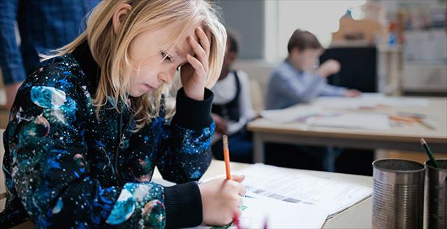 young student looking frustrated while working on a math problem