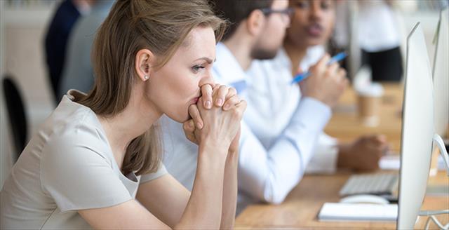 woman sitting at a conference table looking tense