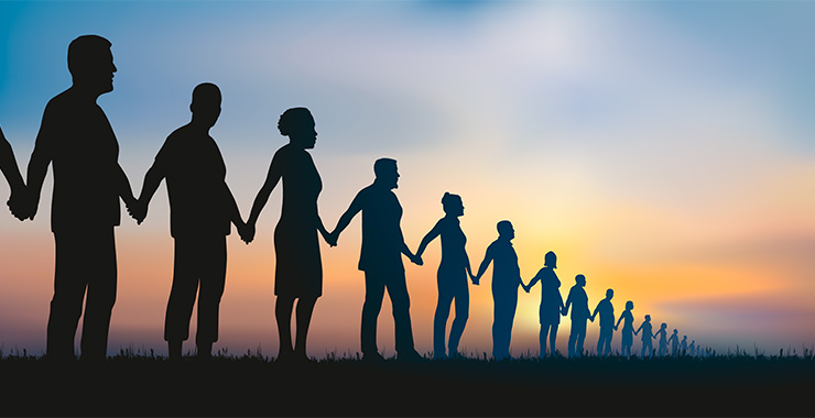 silhouettes of people holding hands in a long line at sunset
