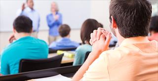 two adult instructors in front of a room of students