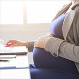 pregnant woman sitting at a laptop