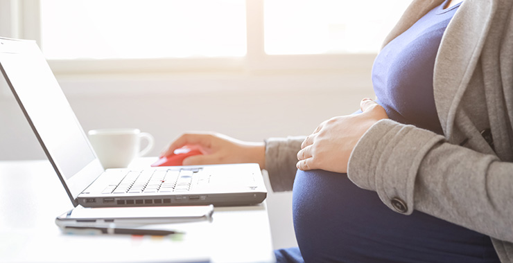 pregnant woman sitting at a laptop