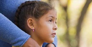 young girl being comforted by her mother