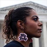 young woman wearing "my body" earrings