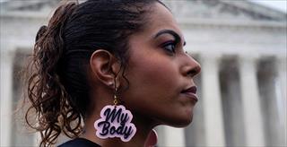 young woman wearing "my body" earrings