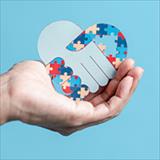 hand holding an autism puzzle symbol