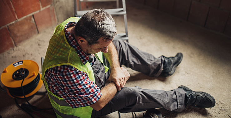 man sitting on the ground holding his arm