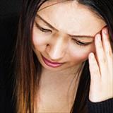 woman with hand on head looking stressed