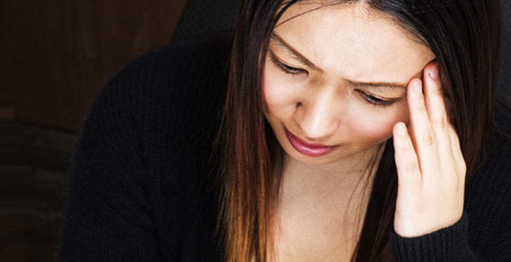 woman with hand on head looking stressed
