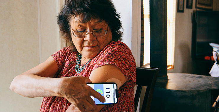 woman checking her blood sugar levels with a smart phone