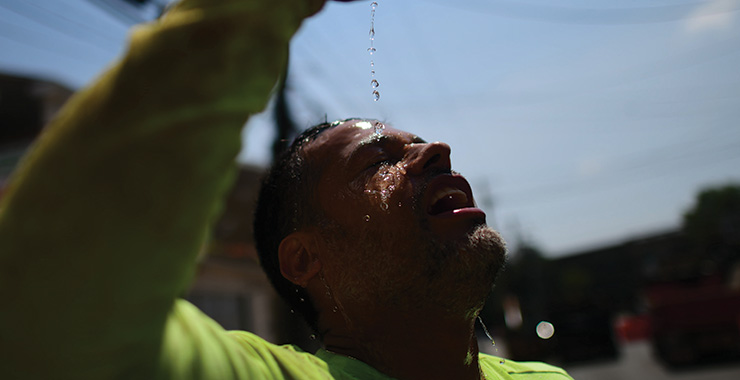 construction worker pour water on his head to cool off