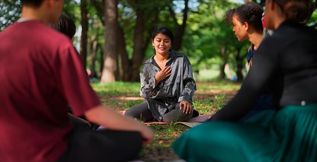 smiling woman sitting outside on the ground