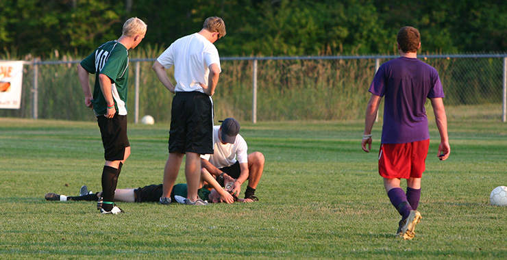 athlete laying on a playing field after being injured