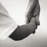 adult holding the hand of a child