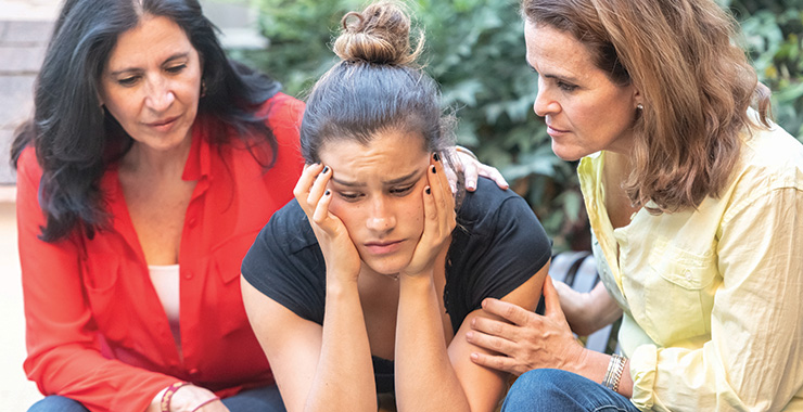 two women comforting another woman