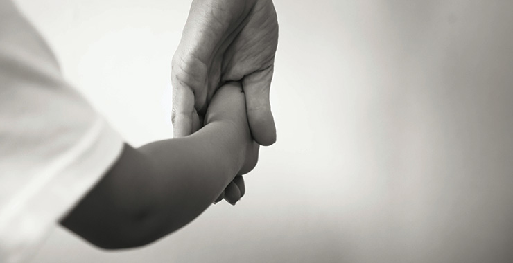 adult holding the hand of a child