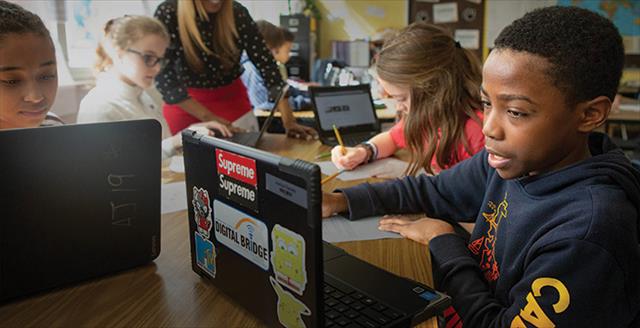 students using laptops in a classroom
