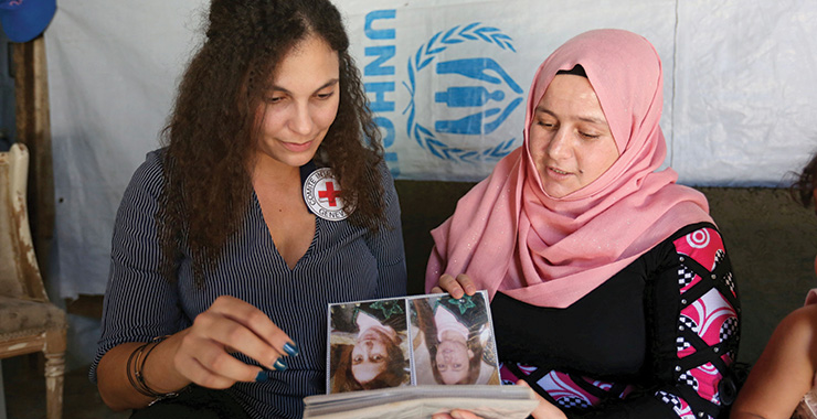 aid woman looking at photos with another woman