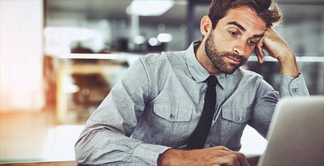 bored man in front of a laptop