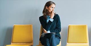 nervous woman sitting on one of 3 chairs