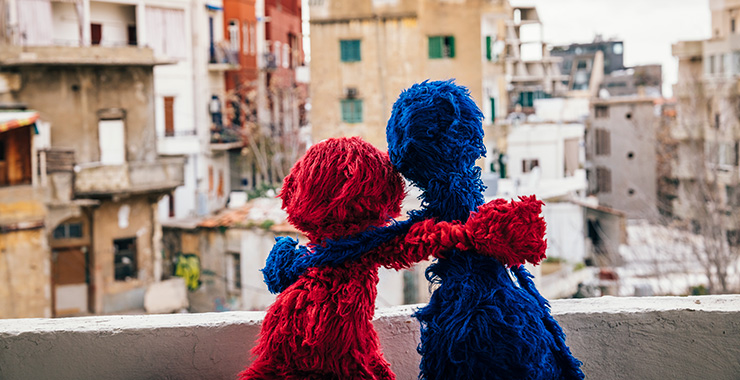 two muppets arm in arm looking out at a neighborhood