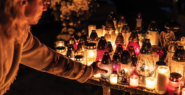 person lighting a candle in memory of someone