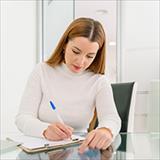 seated woman writing in a notebook