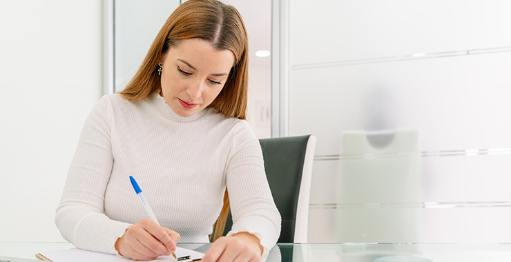 seated woman writing in a notebook