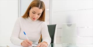 seated woman writing in a notebook