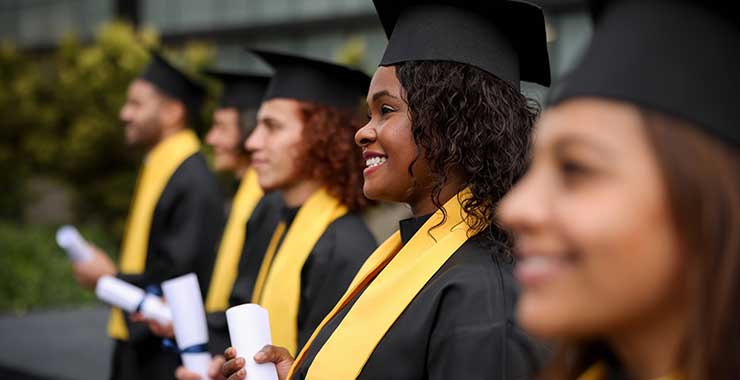 graduates holding diplomas