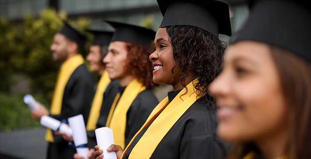 graduates holding diplomas