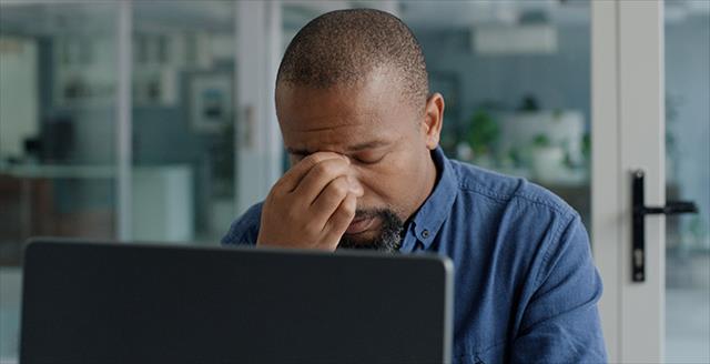 man sitting in front of a computer looking concerned