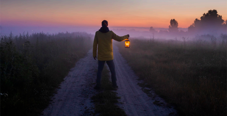 person walking with a lantern
