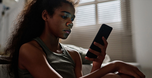 young woman looking at a cell phone screen