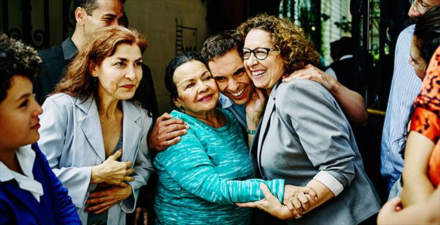 group of adults looking happy and hugging