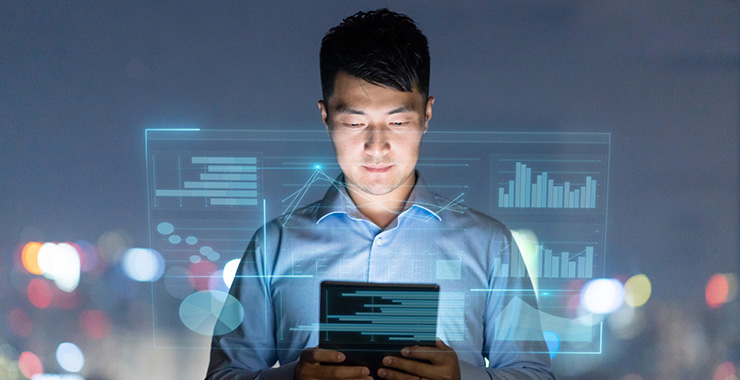 man looking at a smart tablet looking at graphs and figures