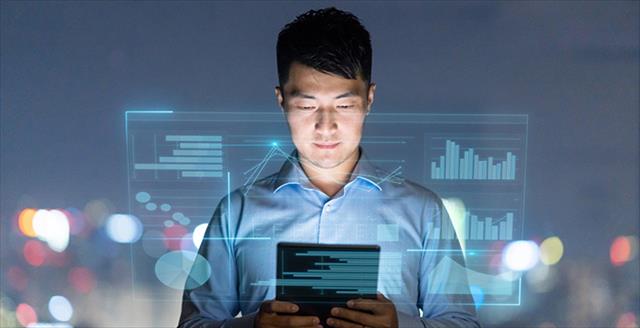 man looking at a smart tablet looking at graphs and figures