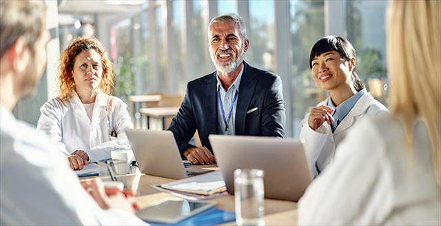 people with laptops at a conference table