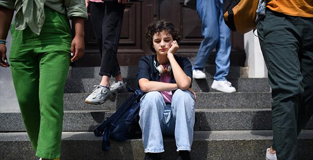 young woman sitting on steps of a building