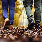 two people walking in a wooded area